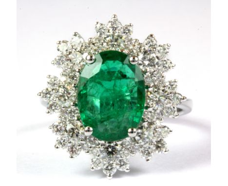 An 18ct white gold large emerald and diamond set cluster ring, (approx. 2.72ct emerald, 1.35ct diamonds overall) (N).