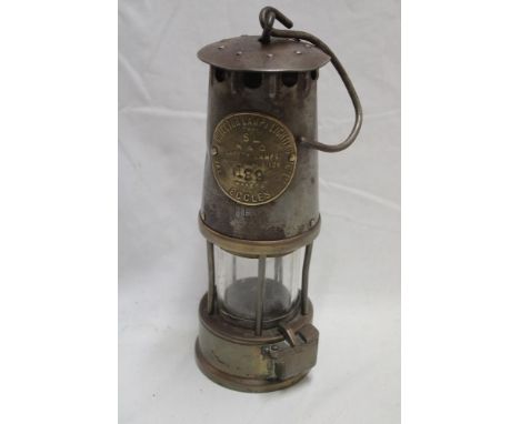 A steel and  brass miner's lamp by the Protector Lamp and Lighting Co.