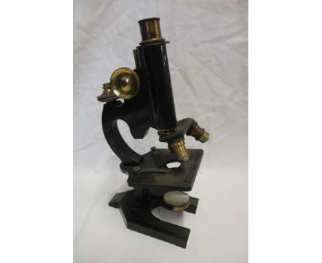 A brass and painted metal monocular microscope by R &amp; J Beck of London in fitted case with accessories