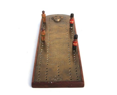 A Grenadier Guards trench art cribbage board of  brass on a hardwood base, inscribed with the regiments Battle Honours starti