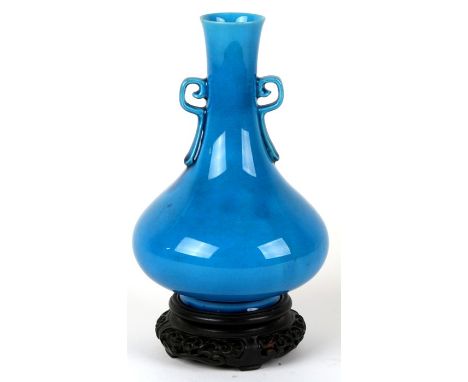 A Chinese turquoise glaze two-handled vase with impressed seal mark to the underside, on a pierced hardwood stand, 21cms (8.2