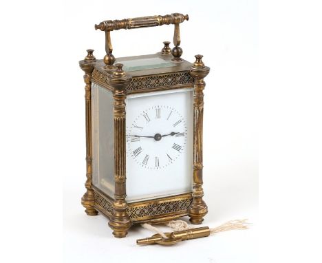 An ornate Edwardian brass cased carriage clock, the white enamel dial with Roman numerals. 13cm (5 ins) high