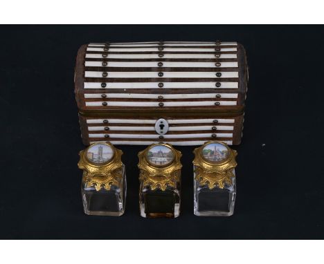 A 19th century Palais Royale scent bottle casket fitted with three gilt metal mounted scent bottles, each with architectural 