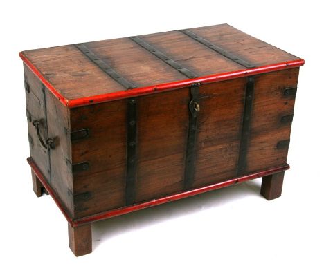A hardwood trunk with iron strapwork, on block feet, 67cms (26.5ins) wide.
