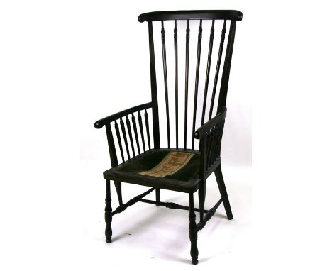 An Arts &amp; Crafts ebonised stick back armchair with upholstered seat, on turned legs joined by an 'H' stretcher.