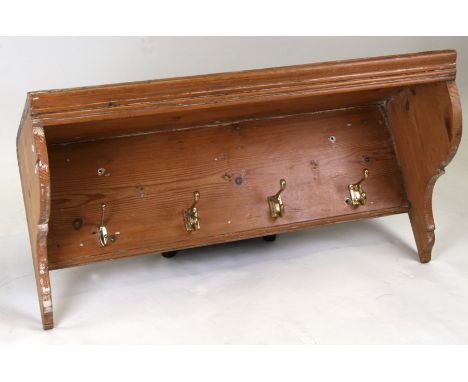 A pine hanging shelf with four brass coat hooks beneath, 92cms (36ins) wide.