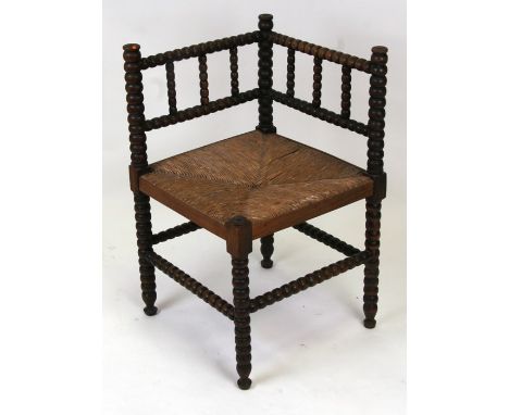 A Victorian corner occasional corner chair with bobbin turned supports and rush seat.