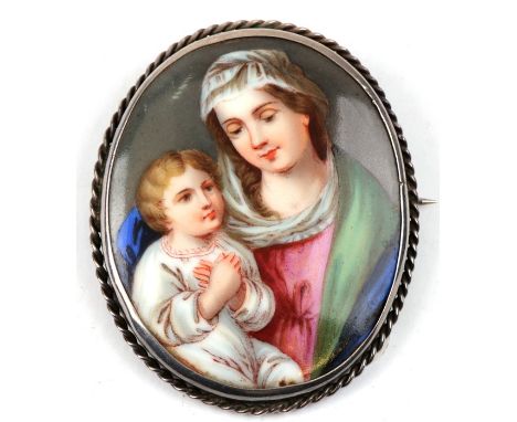 An oval miniature portrait porcelain plaque depicting the Madonna &amp; Child, mounted as a brooch, 5 by 6cms (2 by 2.25ins).