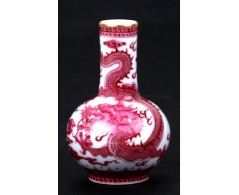 A Chinese porcelain bottle vase decorated pink dragons amongst clouds chasing a flaming pearl, blue seal mark to the undersid