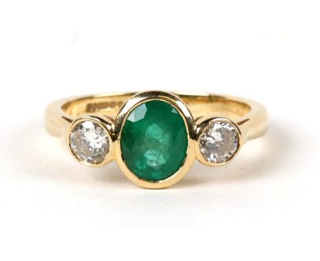 An 18ct gold emerald and diamond three-stone ring, the emerald approx 2ct, the diamonds approx 0.5ct.  Approx. UK size 'O'.  