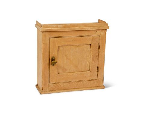 A pine wall hanging cupboard 
With panelled door enclosing a shelf, 49cm wide, 16cm deep, 47cm high.

Provenance:
The Estate 