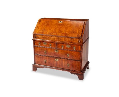 A George I figured walnut and featherbanded bureau
The rectangular top above a sloping fall enclosing a central cupboard door