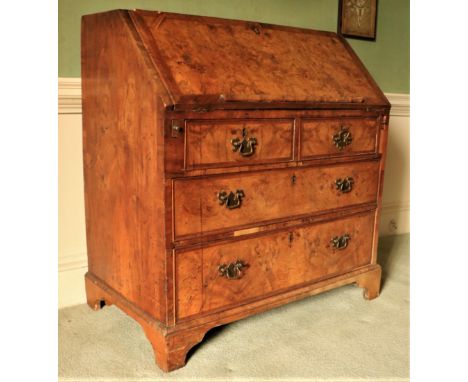 A very fine George II period walnut slope frontÿBureau, the finely figured crossbanded top and drop front with herringbone in