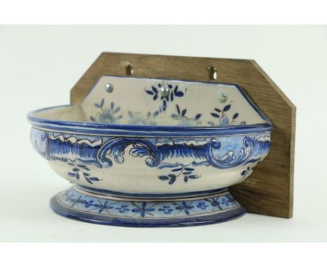A Continental blue and white Faienceÿdemi-lune wall mounted Basin, with armorial crest and decorated with flowers with stem b