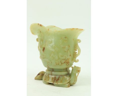 A fine carved Chinese jade Libation Cup, carved in relief with scrolls under a double spout and two open work scroll handles,
