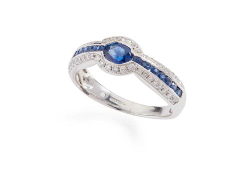 A sapphire and diamond ring Set with an oval-cut sapphire and channel-set round-cut sapphires, in a border of round brilliant