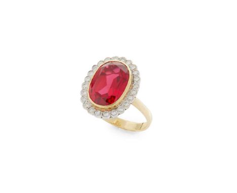 A synthetic ruby and diamond cluster ring Collet-set with an oval-cut synthetic ruby in a border of round brilliant-cut diamo