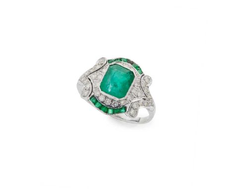 A Belle Époque style emerald and diamond ring Millegrain-set with a cut-cornered rectangular step-cut emerald, in a border of