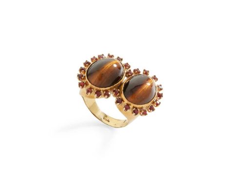 A tiger's eye and garnet dress ring Collet-set two cabochon tiger's eye in a border of round-cut garnets, stamped 750Dimensio