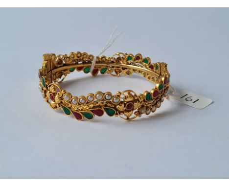 An attractibe yellow metal bracelet encrusted with pearl, emerald &amp; ruby style stones in swirls &amp; drops 