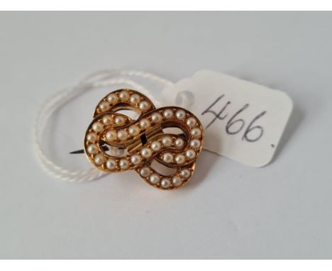 A vintage double knot brooch set with pearls with registration number 90554 set in high carat gold (unmarked)
