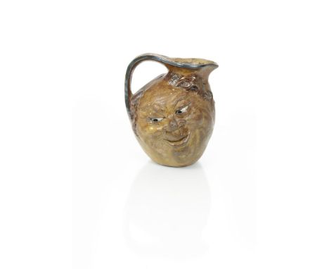 A Martin Brothers stoneware face jug by Robert Wallace Martin,  modelled with a smiling face to both sides, glazed brown, hig