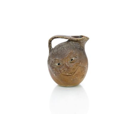 A large Martin Brothers stoneware face jug by Robert Wallace Martin, dated 1897, modelled to both sides with a smiling face, 