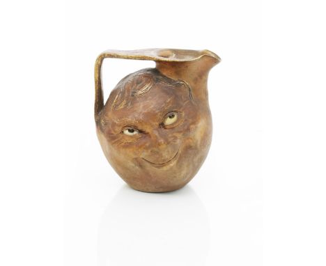 A large Martin Brothers stoneware face jug by Robert Wallace Martin, modelled to both sides with a smiling face, glazed matt 