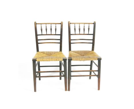 A pair of ebonised wood Sussex chairs, probably Morris & Co, with turned bobbin back, rush seat 84cm. high Literature Linda P