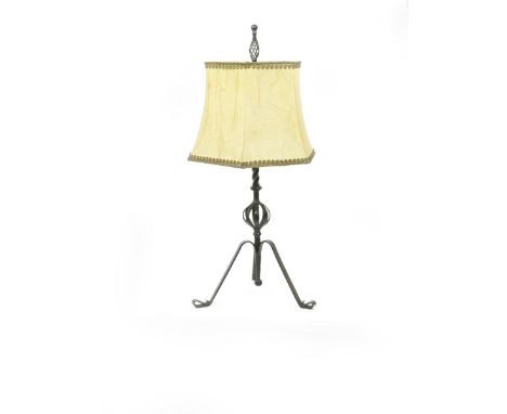 A tall wrought iron lamp,  tripod base with scroll feet, supporting central twisted stem with openwork orb,  and wirework fin