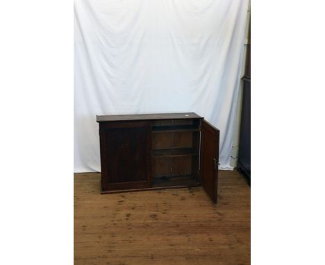 An oak hanging cupboard with two panelled doors opening to reveal an interior shelf on a plinth base.  36¼ins wide.  Est £20-