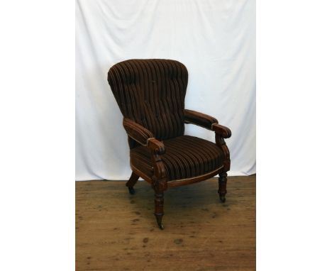 A Victorian mahogany button back chair with over-stuffed arms, scrolled arm terminals, over-stuffed seat on carved legs and c