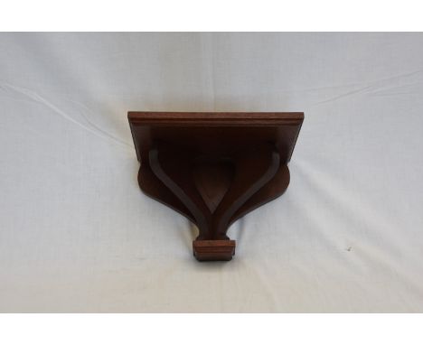 A reproduction mahogany clock bracket.  11ins wide.  Est £10-20