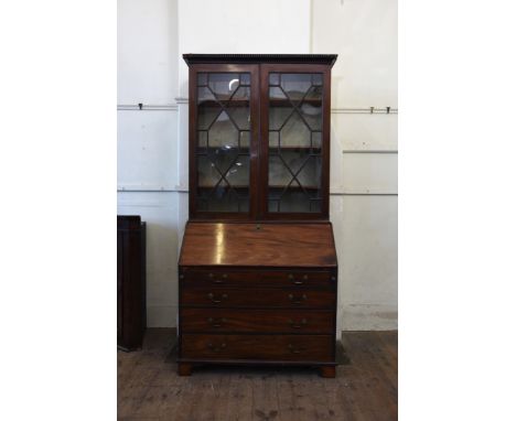 A 19th century mahogany bureau bookcase with dentil pediment above twin astragal glazed doors opening to reveal three interio