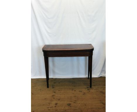 A George III mahogany and walnut card table, the D-shaped fold-over top opening to reveal a green baize lined interior, on sq