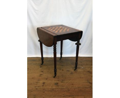 A Victorian mahogany games table, the reversible top with chess and cribbage board to one side, on turned legs and castors (a