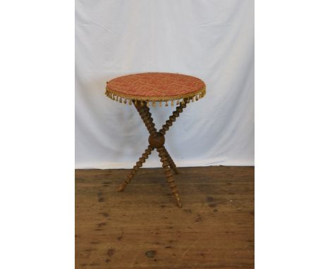 A gypsy table with circular top decorated with a tasselled edge material above bobbin turned tripod supports.  21¼ins diamete