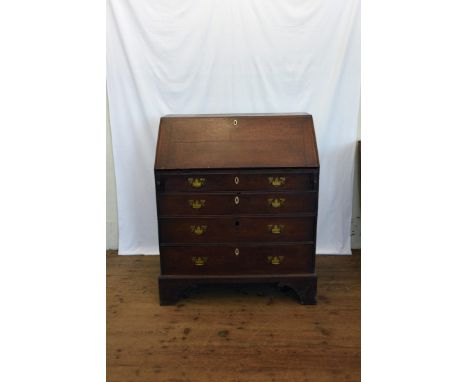 A George III oak bureau, the fall-flap opening to reveal a pigeonholed interior with central cupboard and arrangement of six 