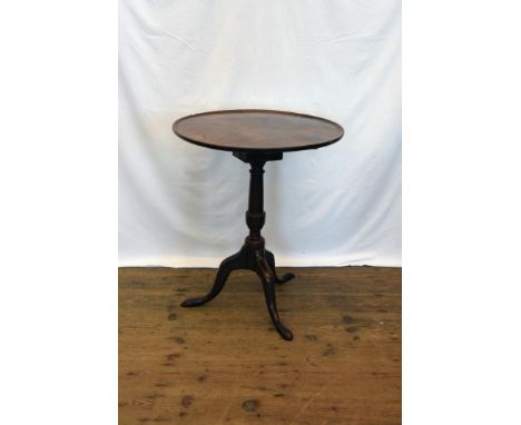 A Georgian mahogany circular tilt-top occasional table, on a turned stem, tripod legs and pad feet (af).  23ins diameter.  Es