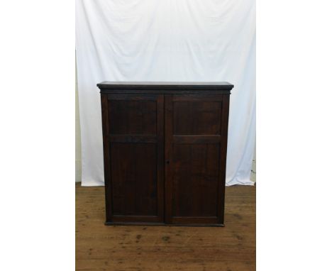 An oak bookcase with twin panelled cupboard doors opening to reveal one adjustable shelf and a fitted lower section.  35¾ins 