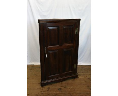 A George III mahogany corner cupboard with quadruple panelled cupboard door opening to reveal an interior shelf.  28½ins wide