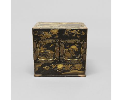 A JAPANESE LACQUERED TABLE CABINET. late 19th century, with two small drawers above cupboards enclosing a fitted interior wit