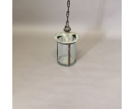 AN ARTS AND CRAFTS COPPER LANTERN. of glazed cylindrical form with flower finial and rigid chain form upright, height 124cm, 