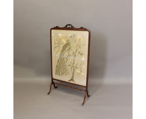 A 19TH CENTURY SILKWORK FIRESCREEN. depicting a peacock seated amongst flowering foliage, in a carved mahogany frame, height 