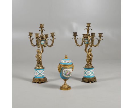 A PAIR OF 19TH CENTURY GILT AND PORCELAIN MOUNTED CANDELABRA. modelled as cherubs holding aloft, scrolling five branch sconce