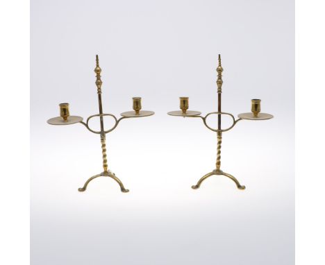 A PAIR OF BRASS ADJUSTABLE CANDELABRA. on turned and twist stems with twin sconces and tripod bases with paw feet, height 34c