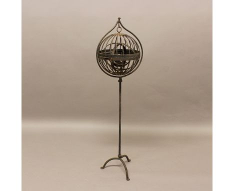 A WROUGHT IRON GIMBAL MARITIME OIL LAMP. of spherical form, on a wrought iron tripod stand, height 125cm. * Rusted throughout