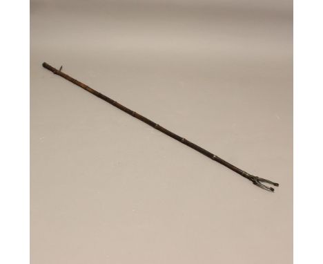 A GEORGE III LIBRARY GRAB. with a bamboo shaft and brass fittings, length 179cm. * Worn and tarnished, mechanism working. **B