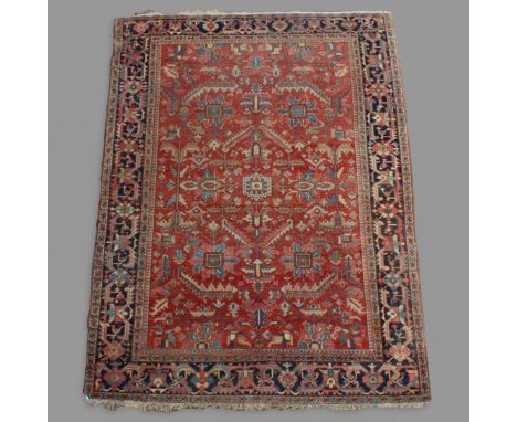 AN HERIZ CARPET, IRANIAN AZERBAIJAN, CIRCA 1900. the abrashed terracotta field of angular serrated leaves, vines and stylised