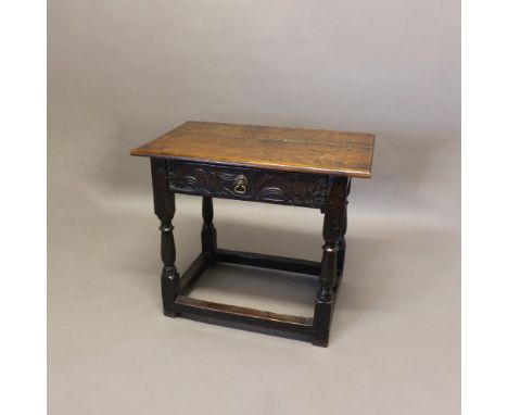 AN 18TH CENTURY OAK SIDE TABLE. the two plank top above a carved single drawer, on turned supports and box stretcher, height 
